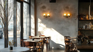 Cozy cafe interior with wooden tables and chairs illuminated by warm wall sconces.